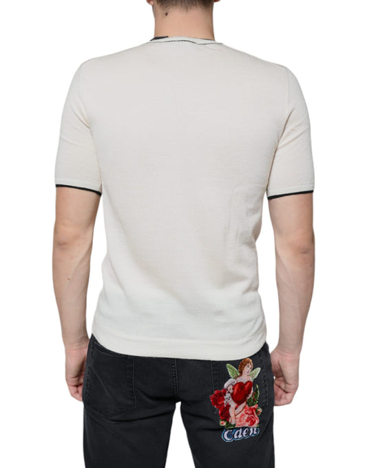Man wearing white shirt with black stripe on sleeve and denim jeans with floral embroidery on back