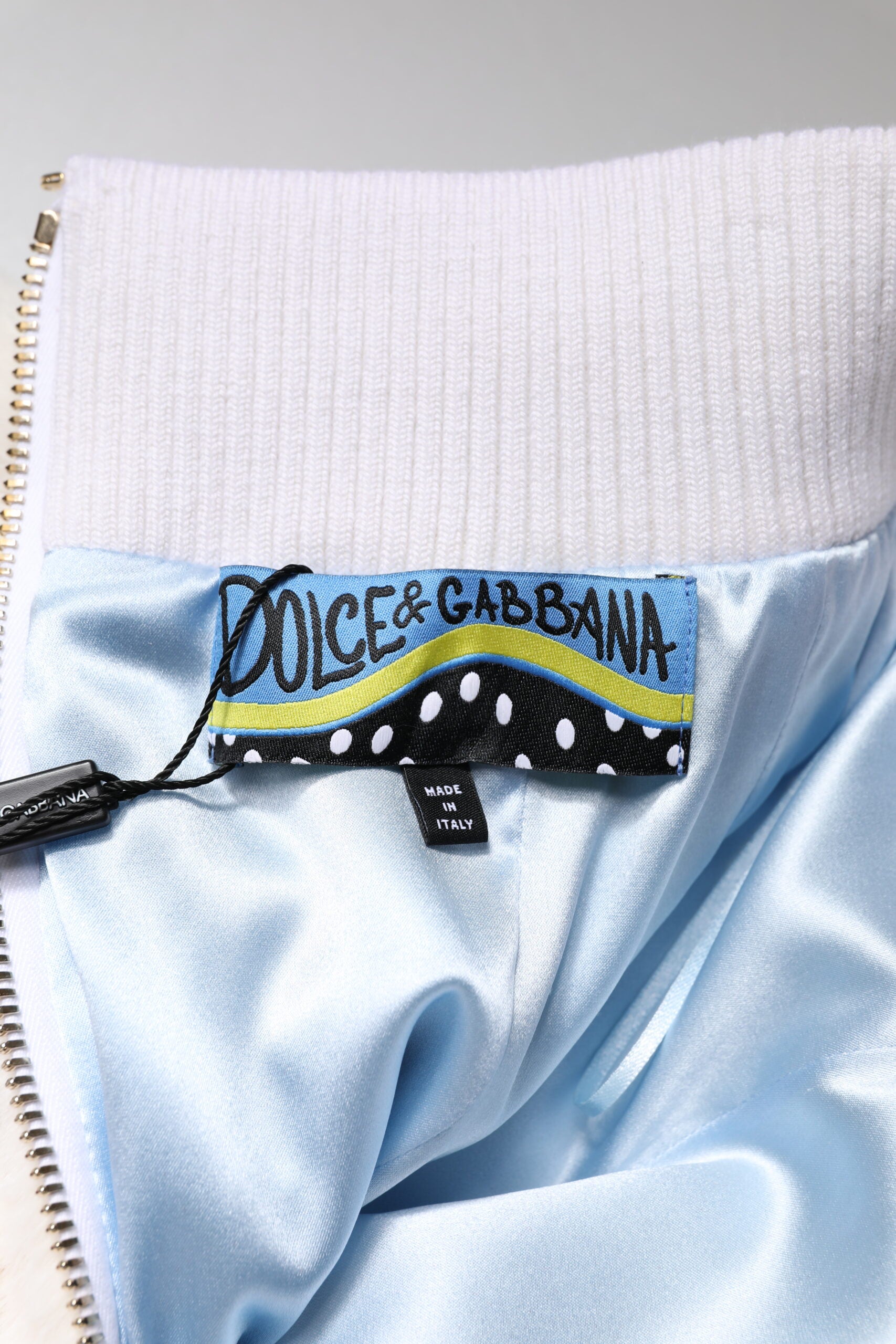 Blue jacket with white zipper and yellow label