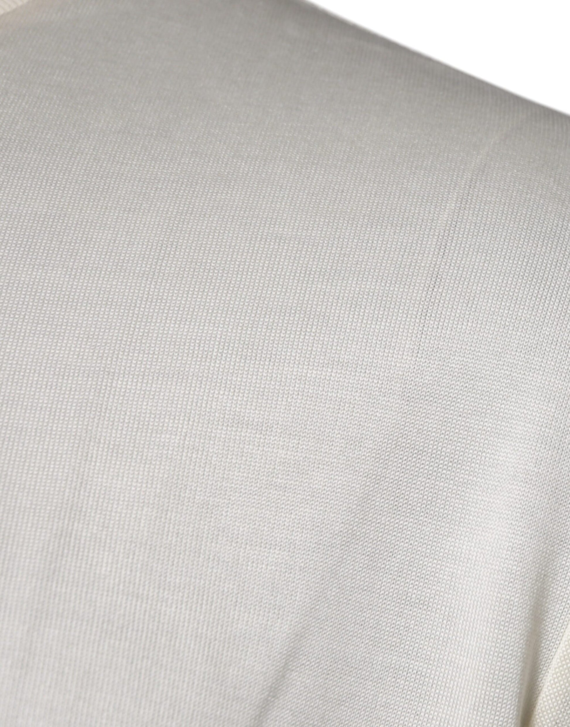 A close-up view of a person's shoulder area wearing a light beige or off-white garment that appears to be a j