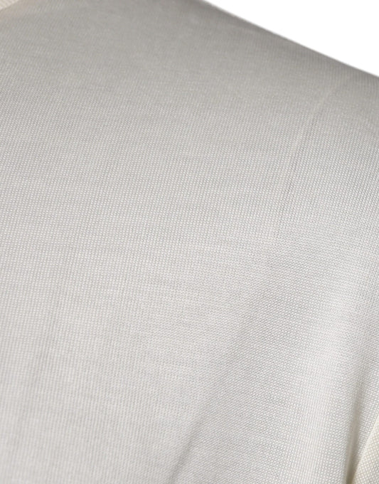 A close-up view of a person's shoulder area wearing a light beige or off-white garment that appears to be a j