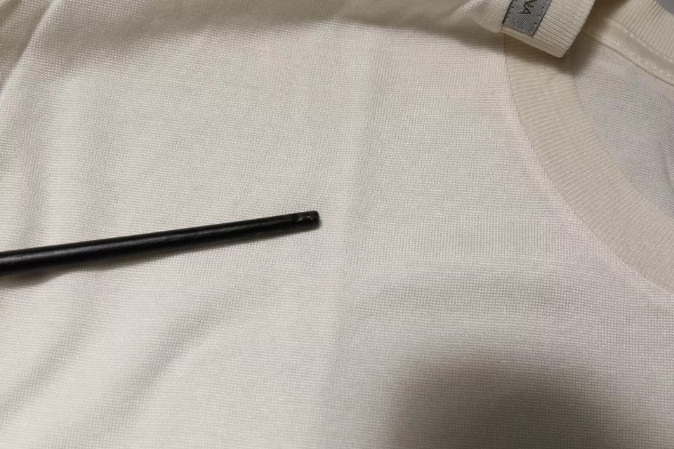 Black plastic clothing pin on fabric