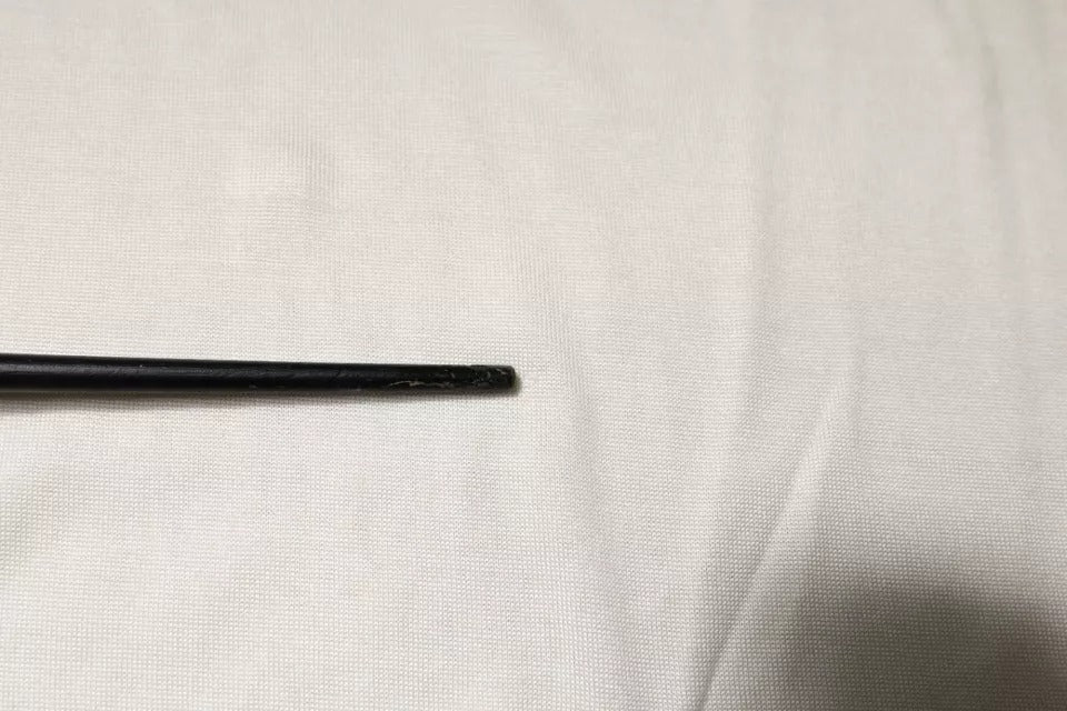 Black metal rod on white surface