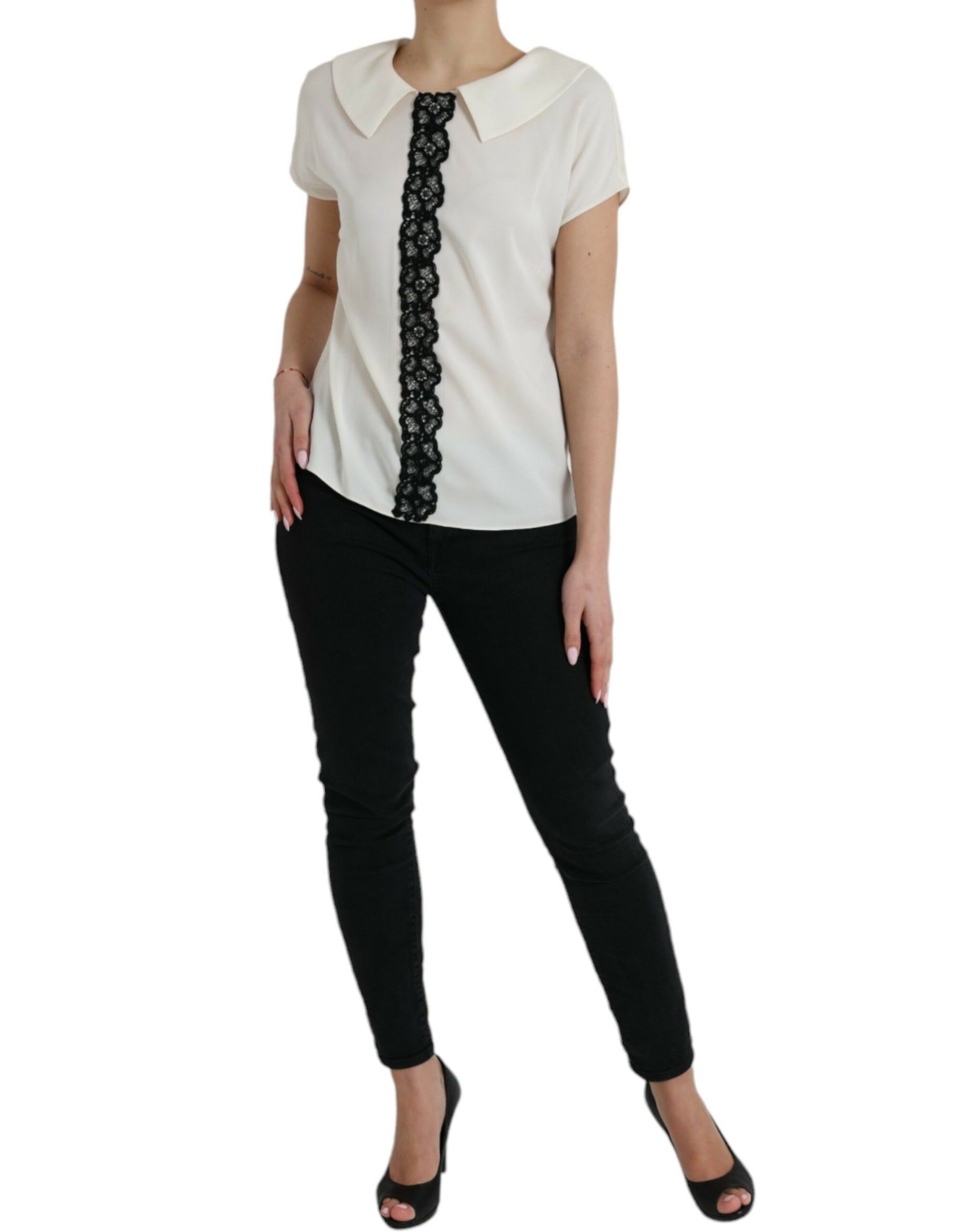 Woman wearing black pants and white blouse with black lace detailing