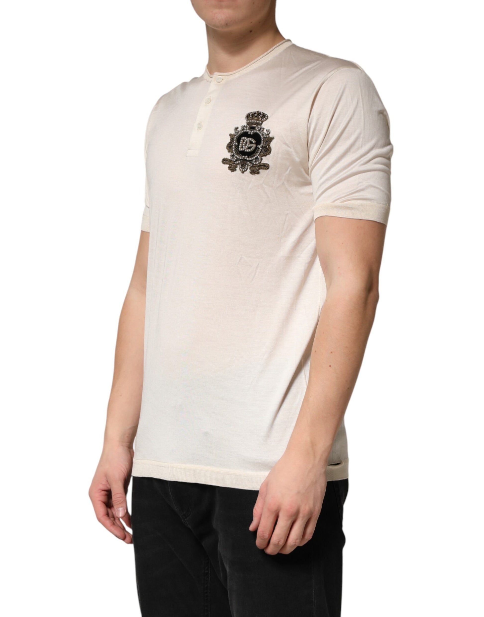 Man wearing a beige sweater with emblem on left chest