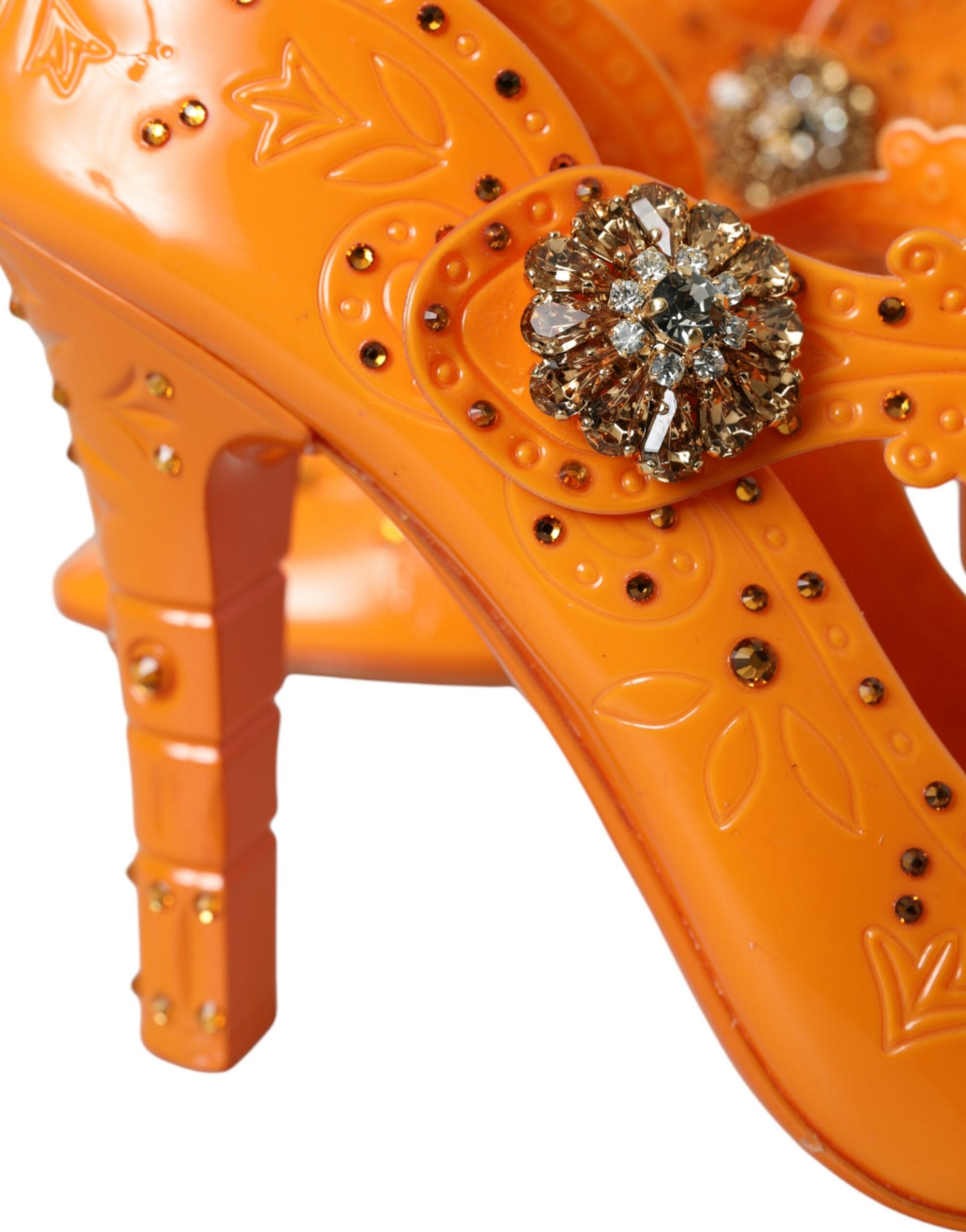 Pair of orange high heel shoes with embellishments and straps