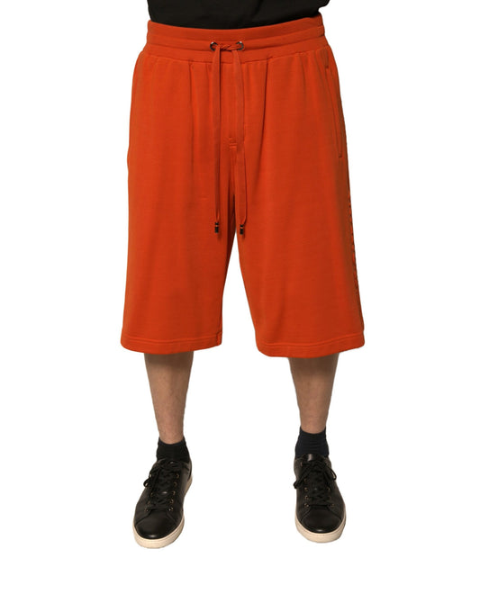 A pair of men's shorts in an orange cotton blend fabric, designed by Dolce & Gabbana. They are bermuda style