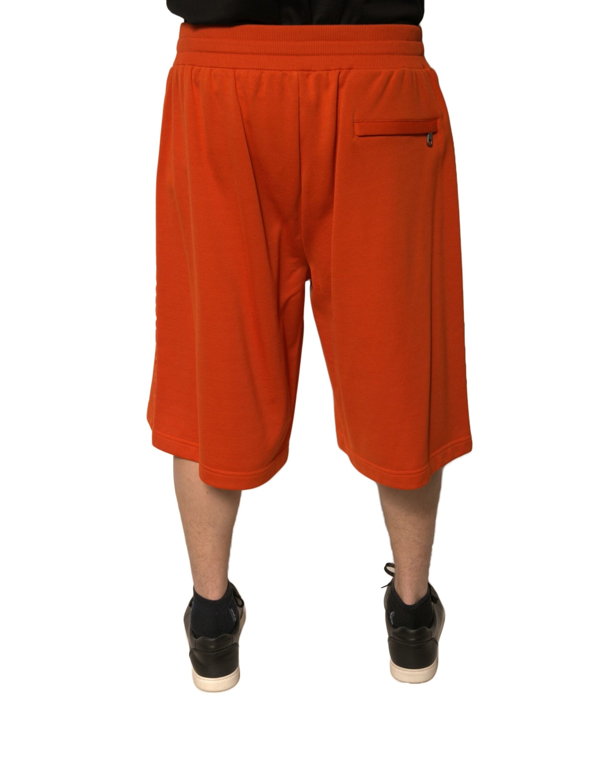 A pair of men's orange cotton blend bermuda shorts with a drawstring waist