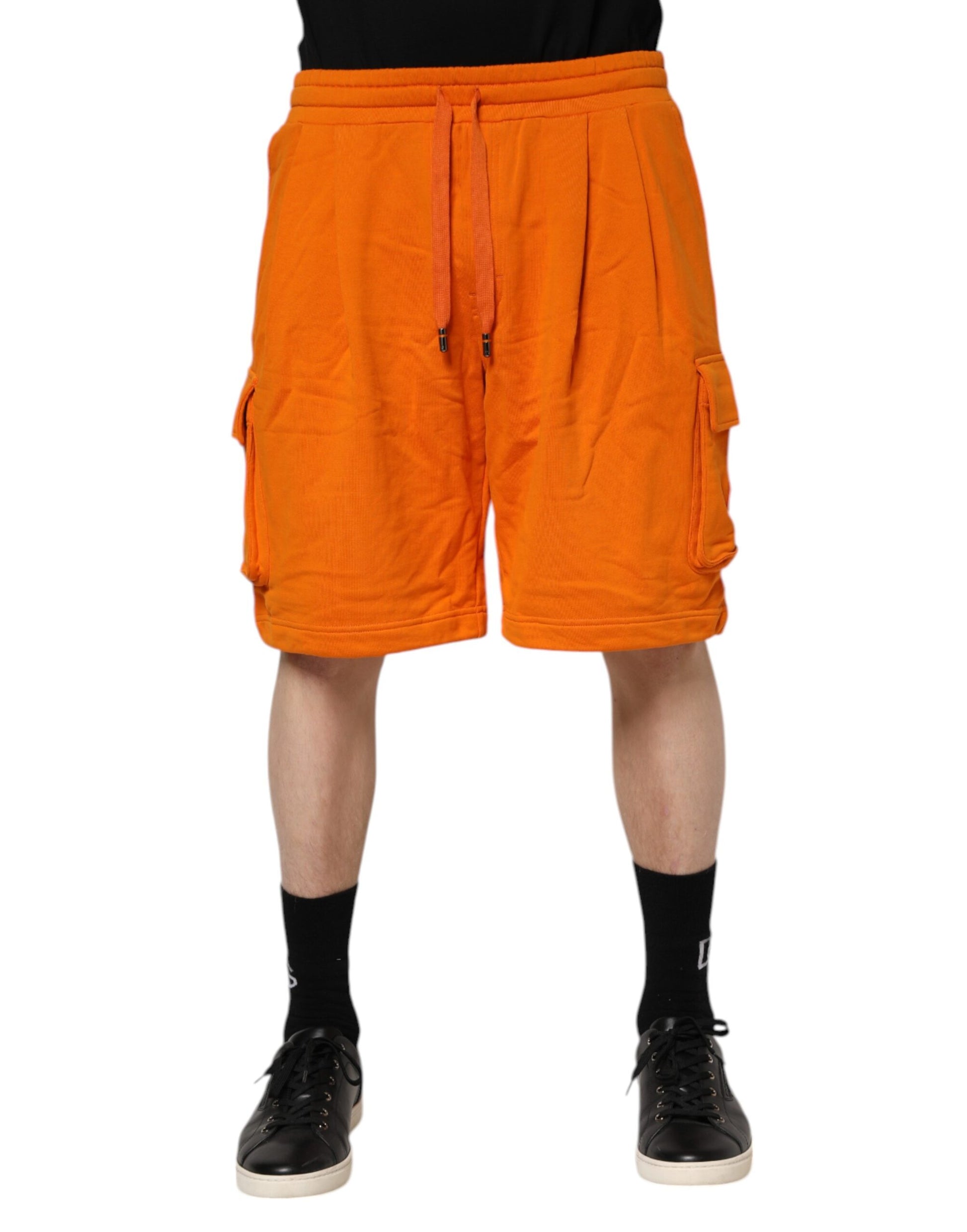 Orange shorts on a person standing against white background