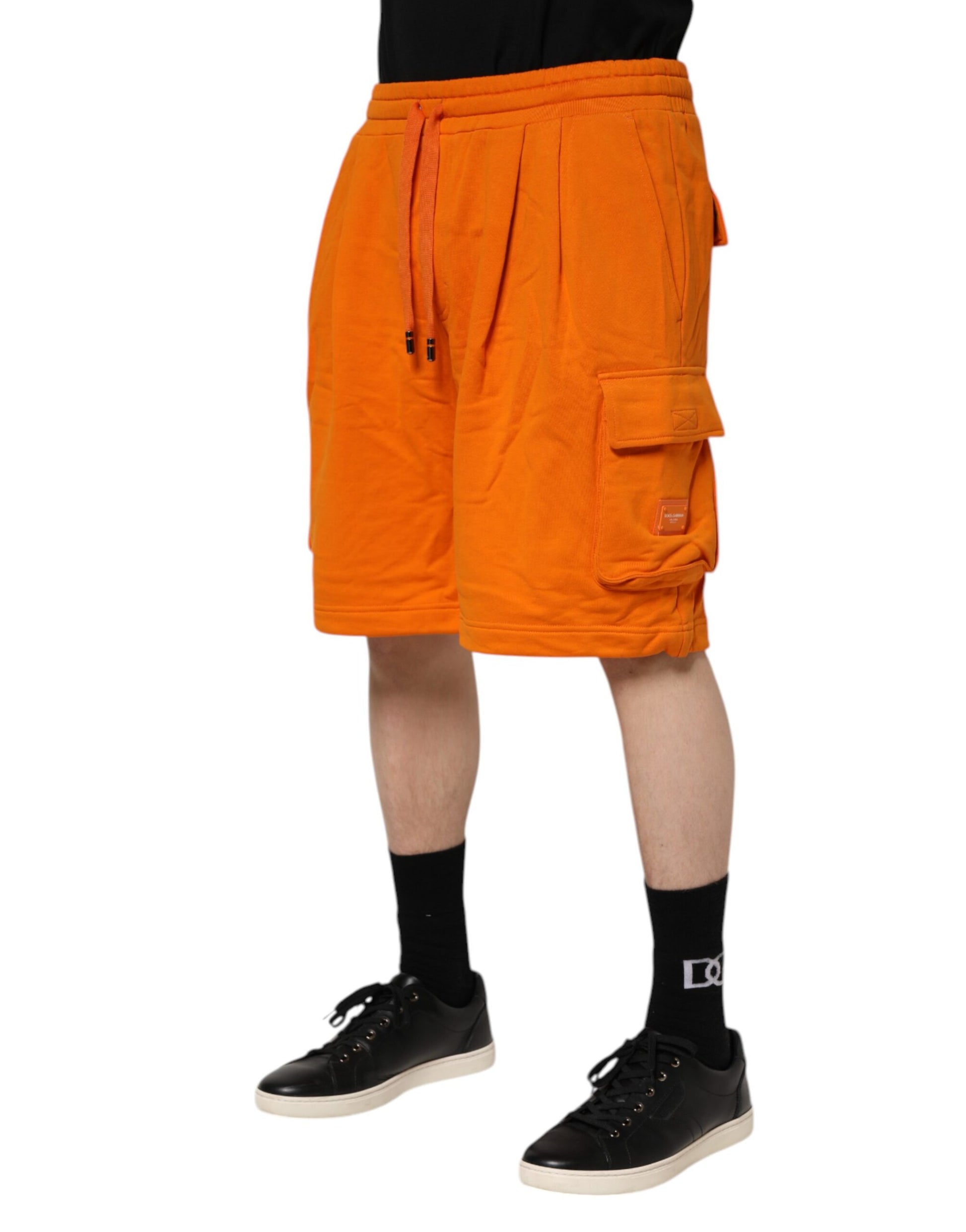 Man wearing orange shorts and black shoes