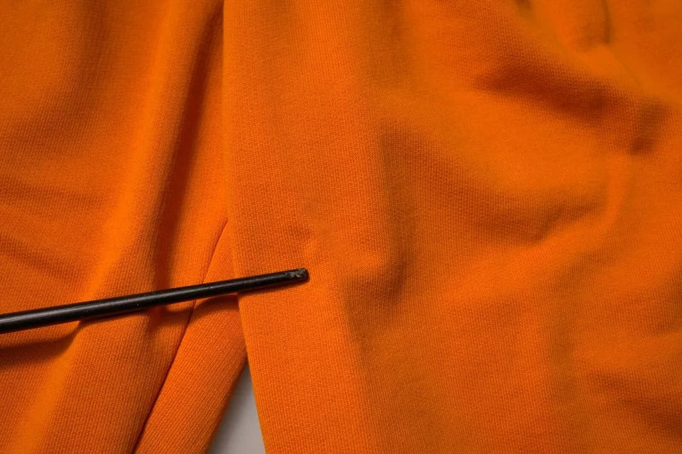 Black metal zipper on orange cotton men's shorts