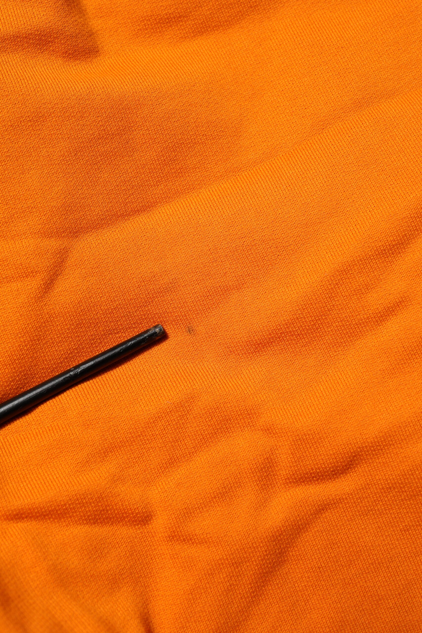 Black pin in orange fabric