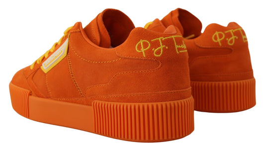 Pair of orange sneakers with yellow laces and white soles