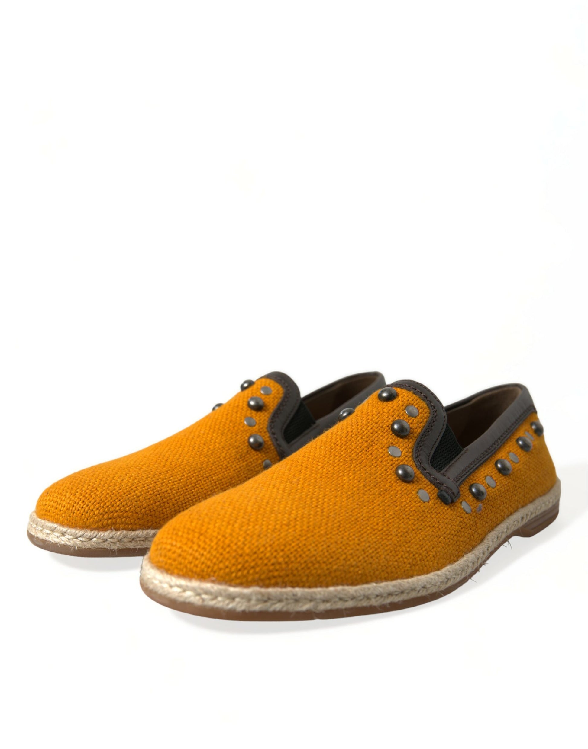 Pair of yellow suede shoes with black laces and silver studs on sides
