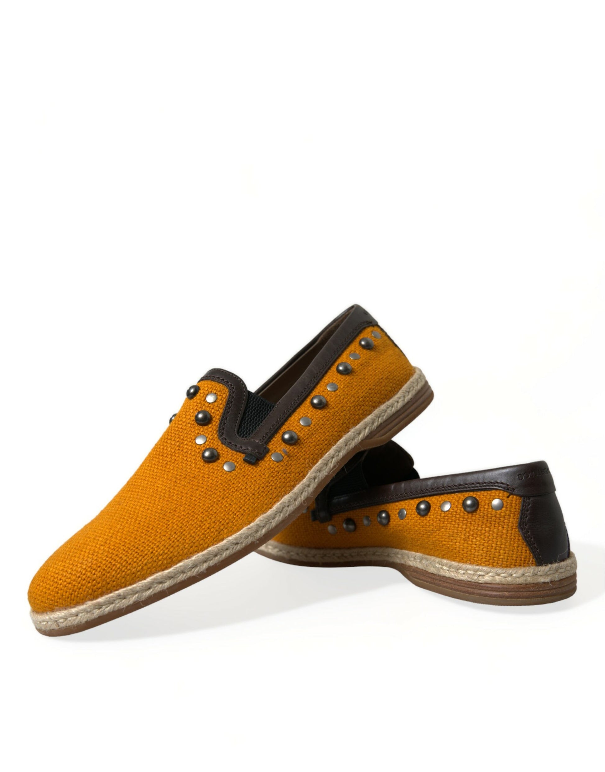 Pair of yellow shoes with brown soles and silver studs on top