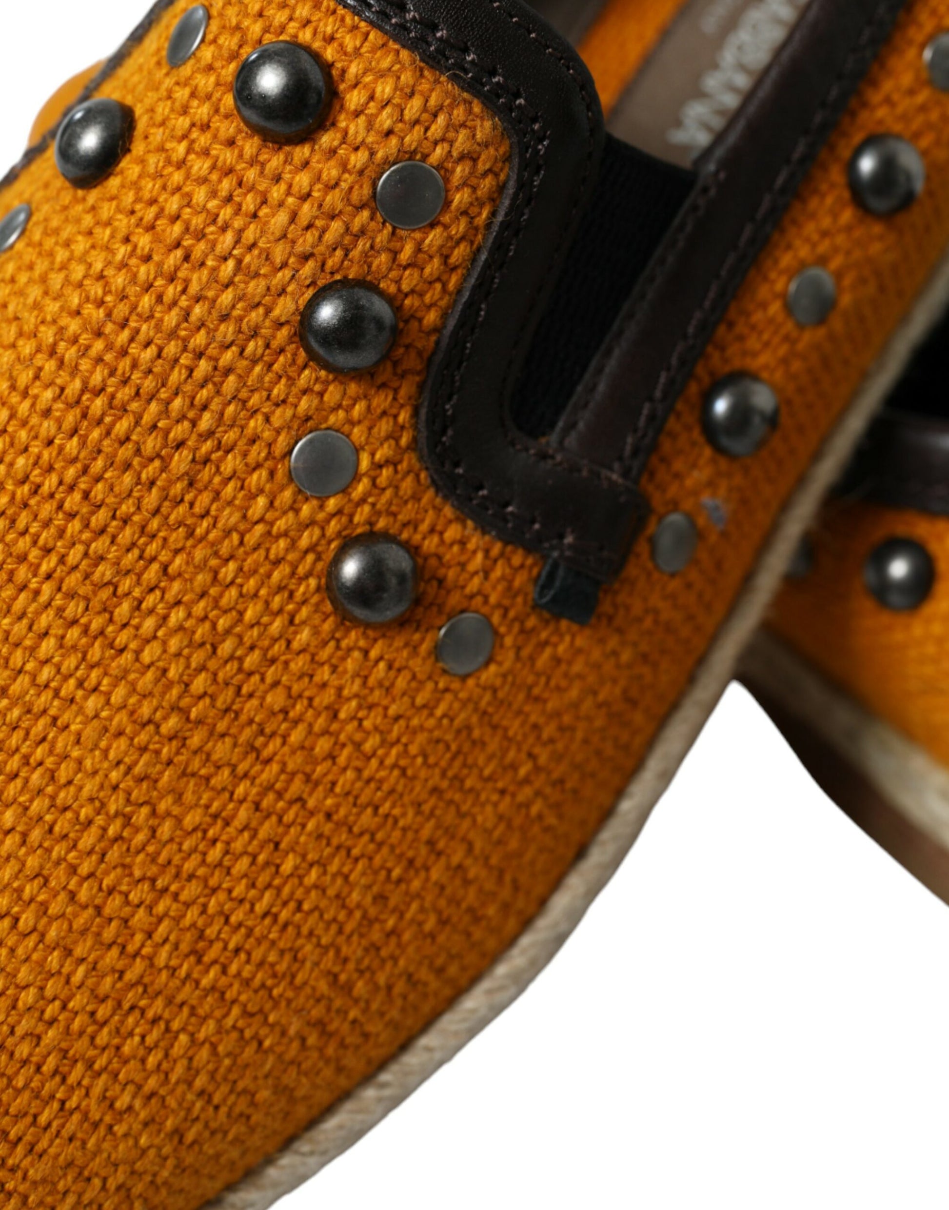 Pair of orange shoes with black laces and silver studs on side