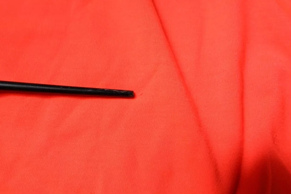 Black eyeliner pencil on red fabric