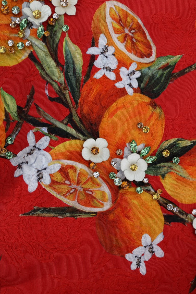 Decorative fabric with orange flowers and citrus fruits on a red background