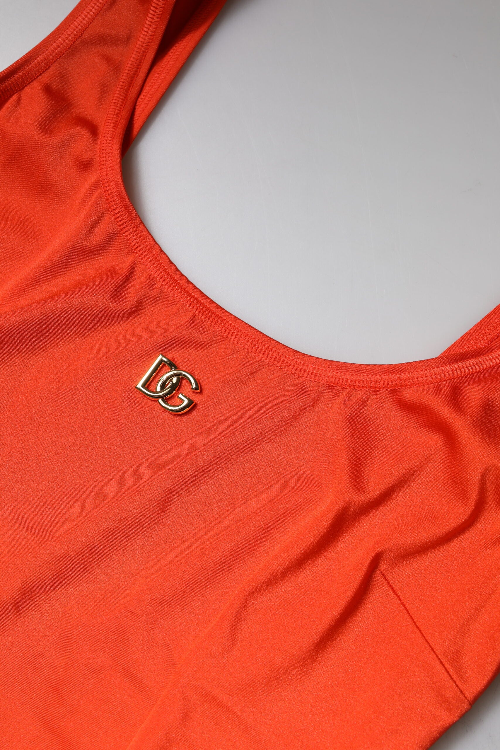Red sleeveless bodycon jumpsuit dress with gold logo on chest