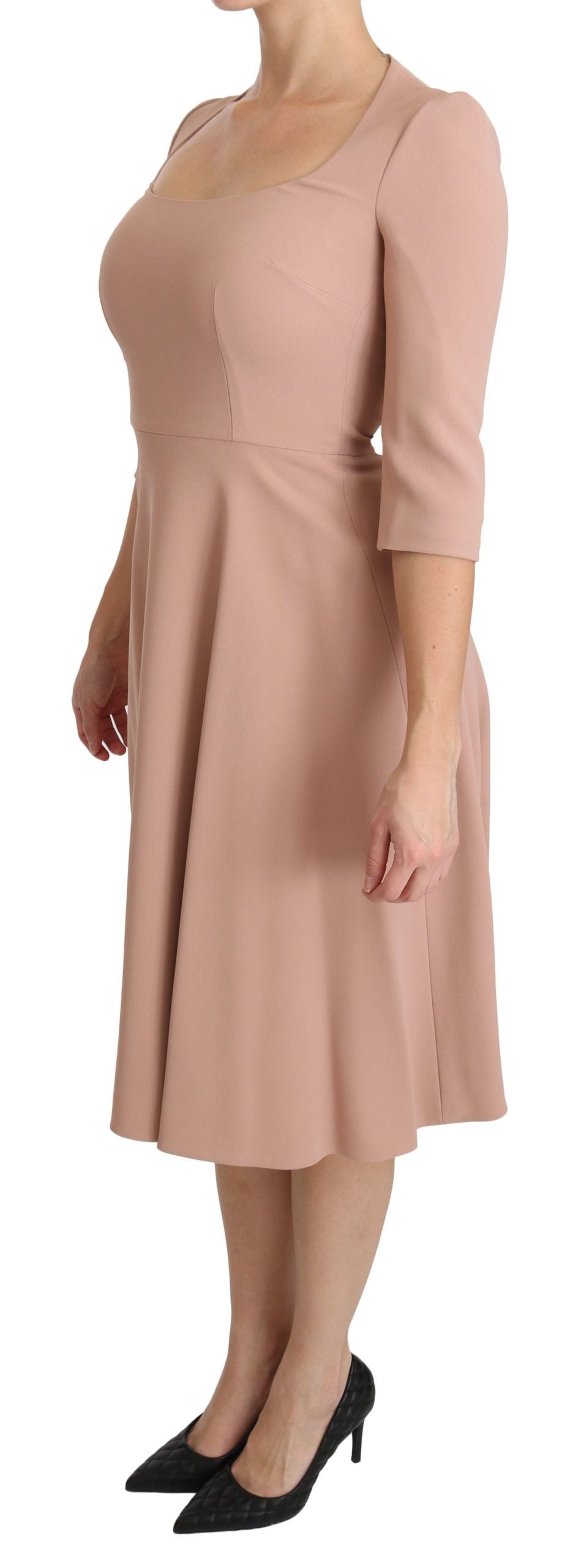 A woman wearing a pink dress with a V-neck and three-quarter sleeves. It is an A-line style made of viscose f