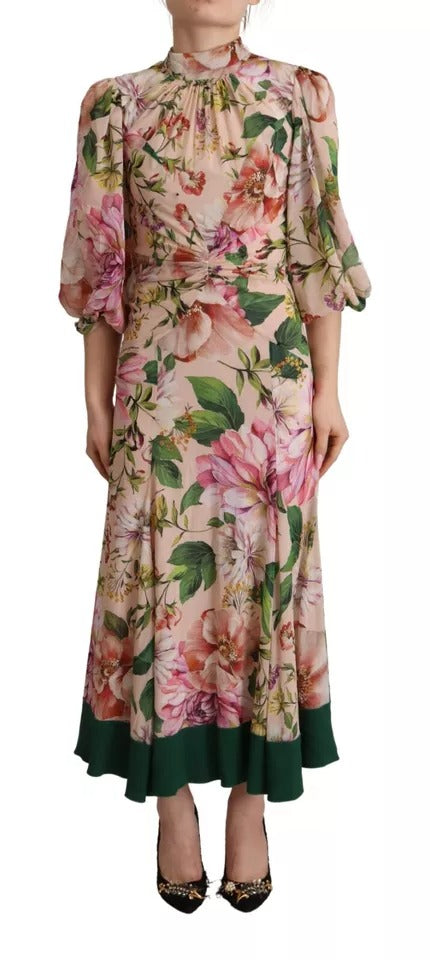 A long, pink floral dress with an A-line silhouette and a pussy bow at the neck. It features a sheer overlay
