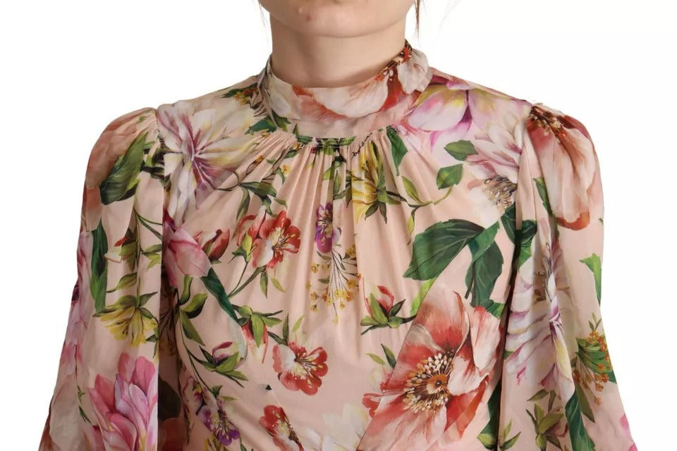 A pink floral print dress with long sleeves and a pussy bow neckline. It is an A-line style, which means it h