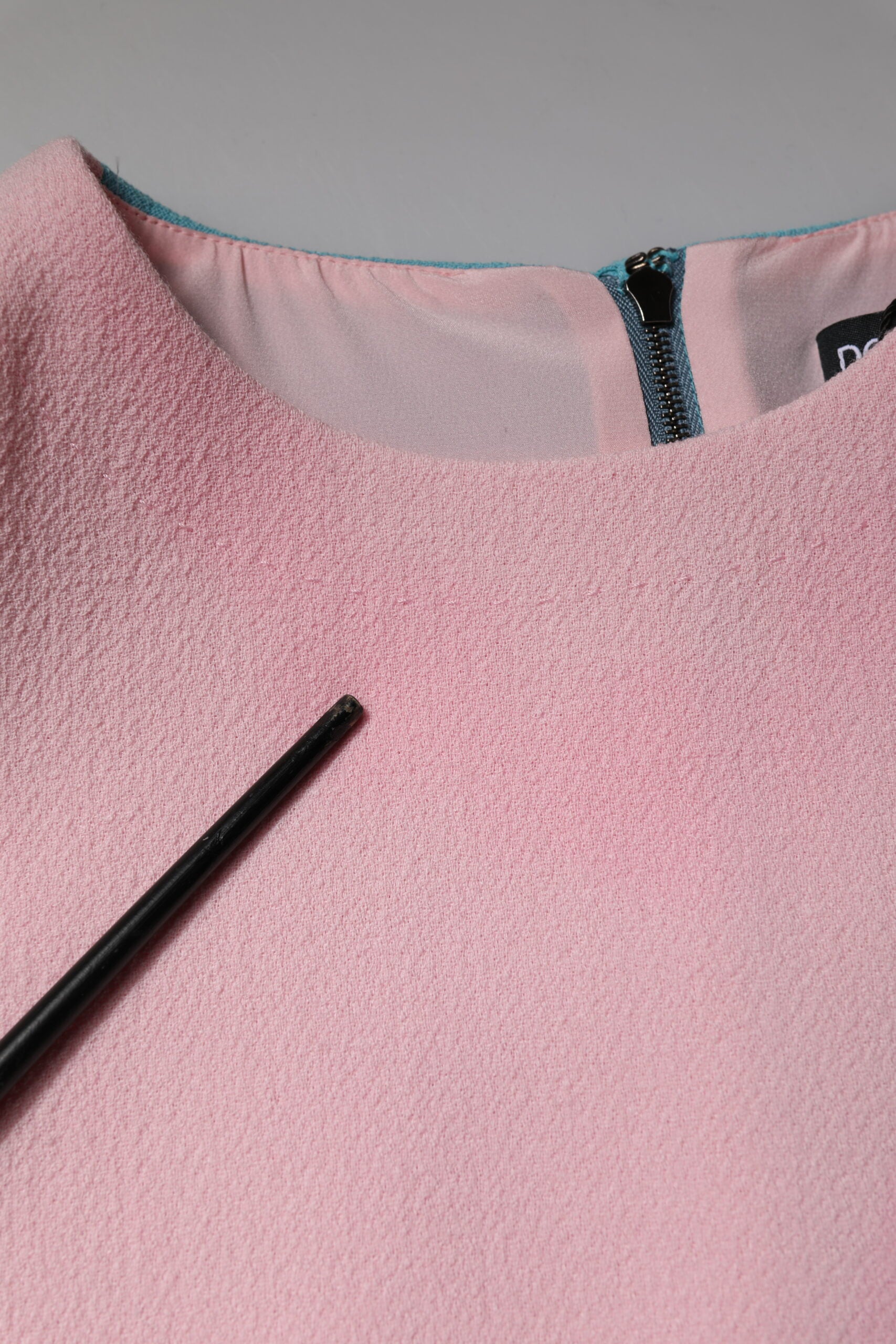 A pink wool dress with a blue trim and long sleeves
