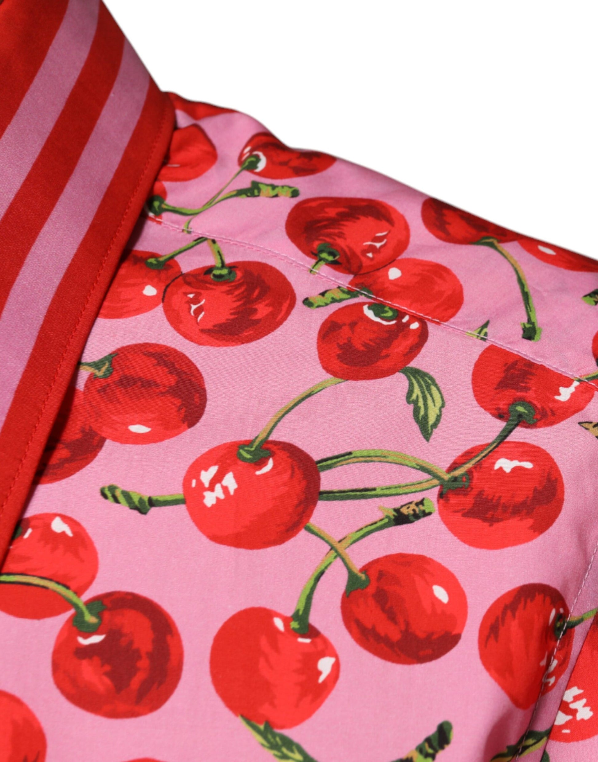 A pink cherry print shirt with a red collar and cuffs
