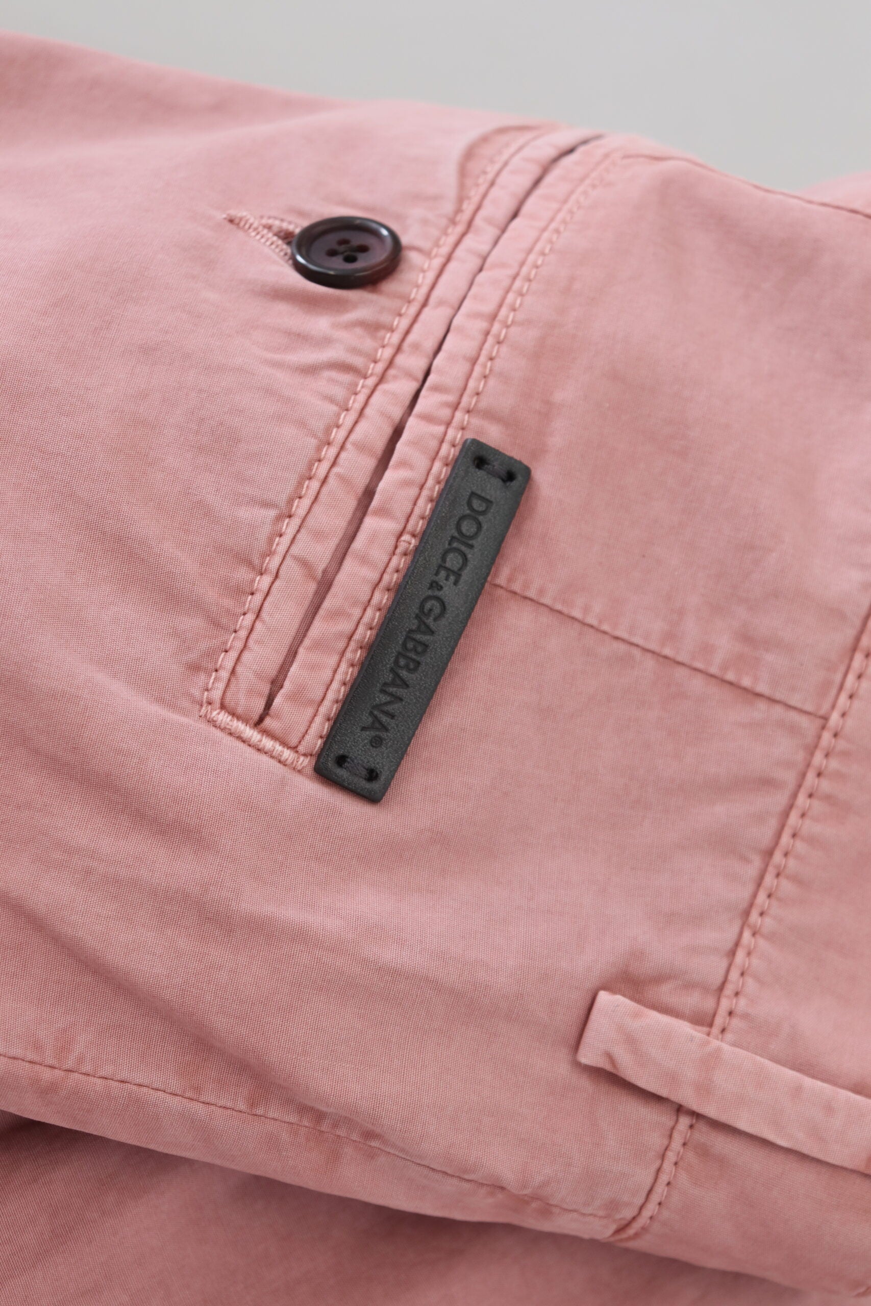 Pink chino pants with black label on pocket