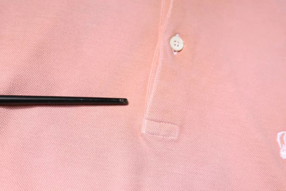 Black button on pink fabric
