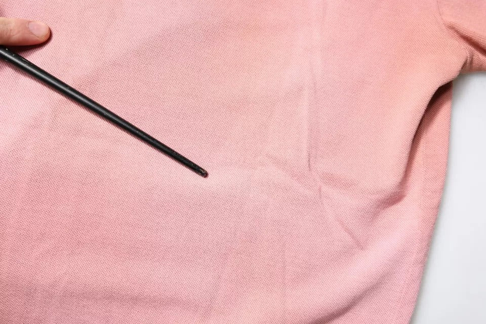 Pink cloth with black pins on top
