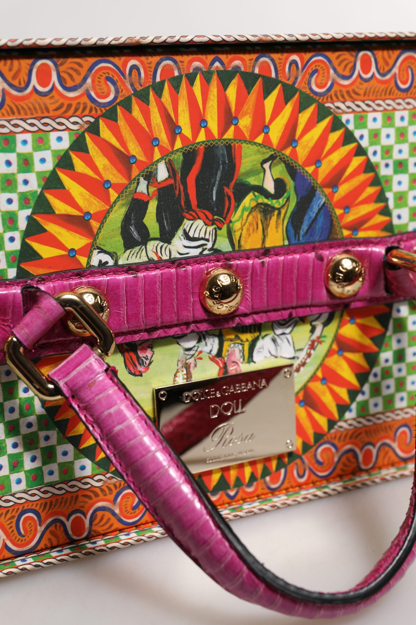 A pink leather handbag with gold accents