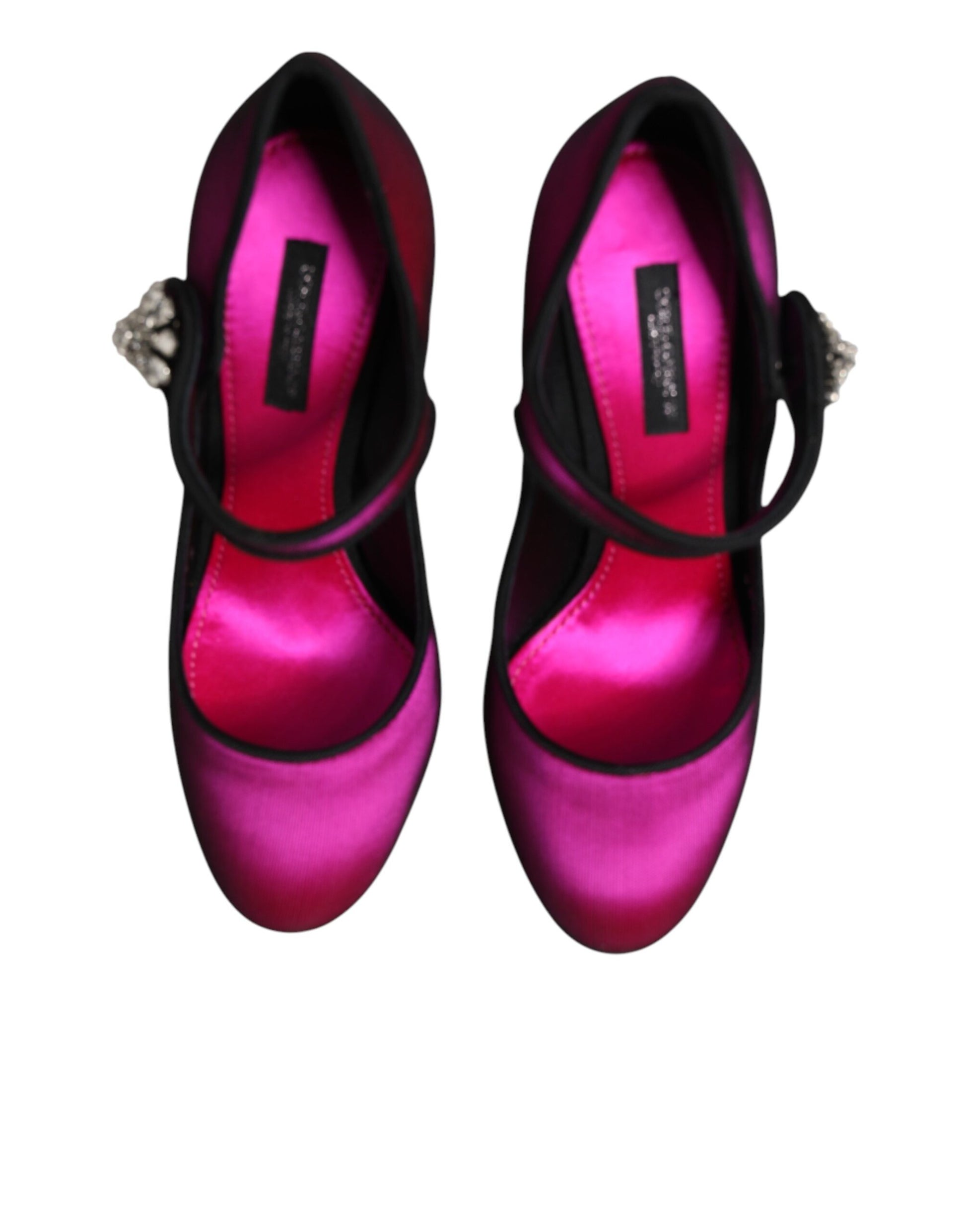Pair of pink satin shoes with black straps and heels