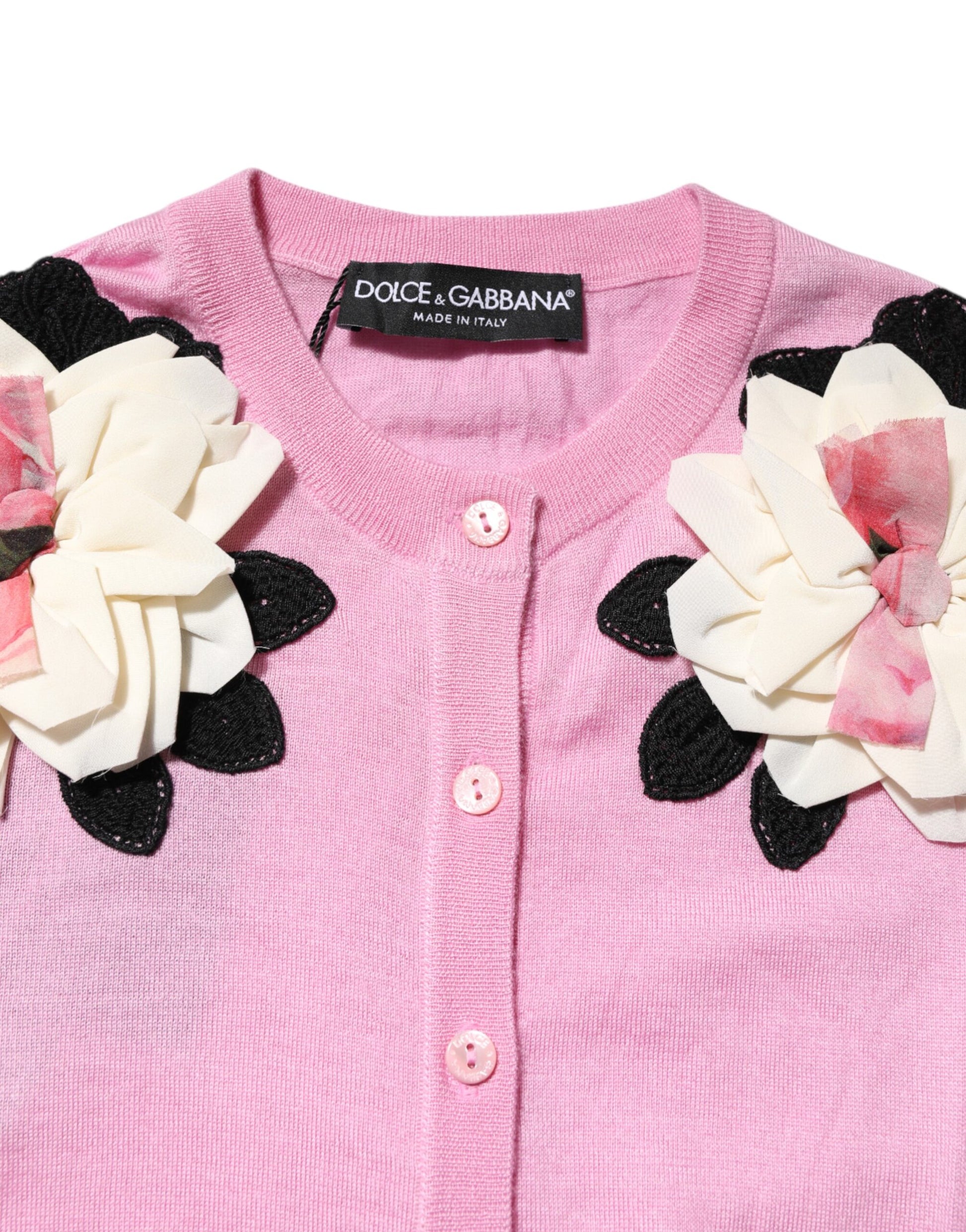 Pink sweater with floral embellishments on front