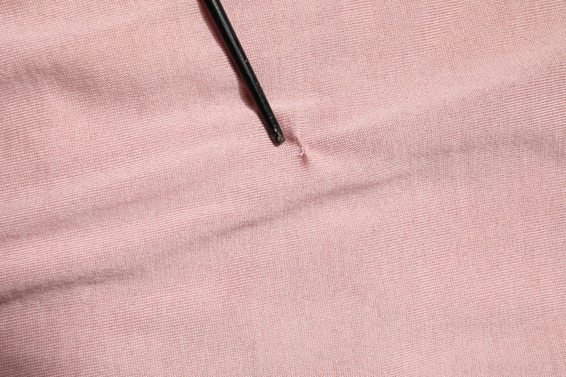 Black button on pink fabric