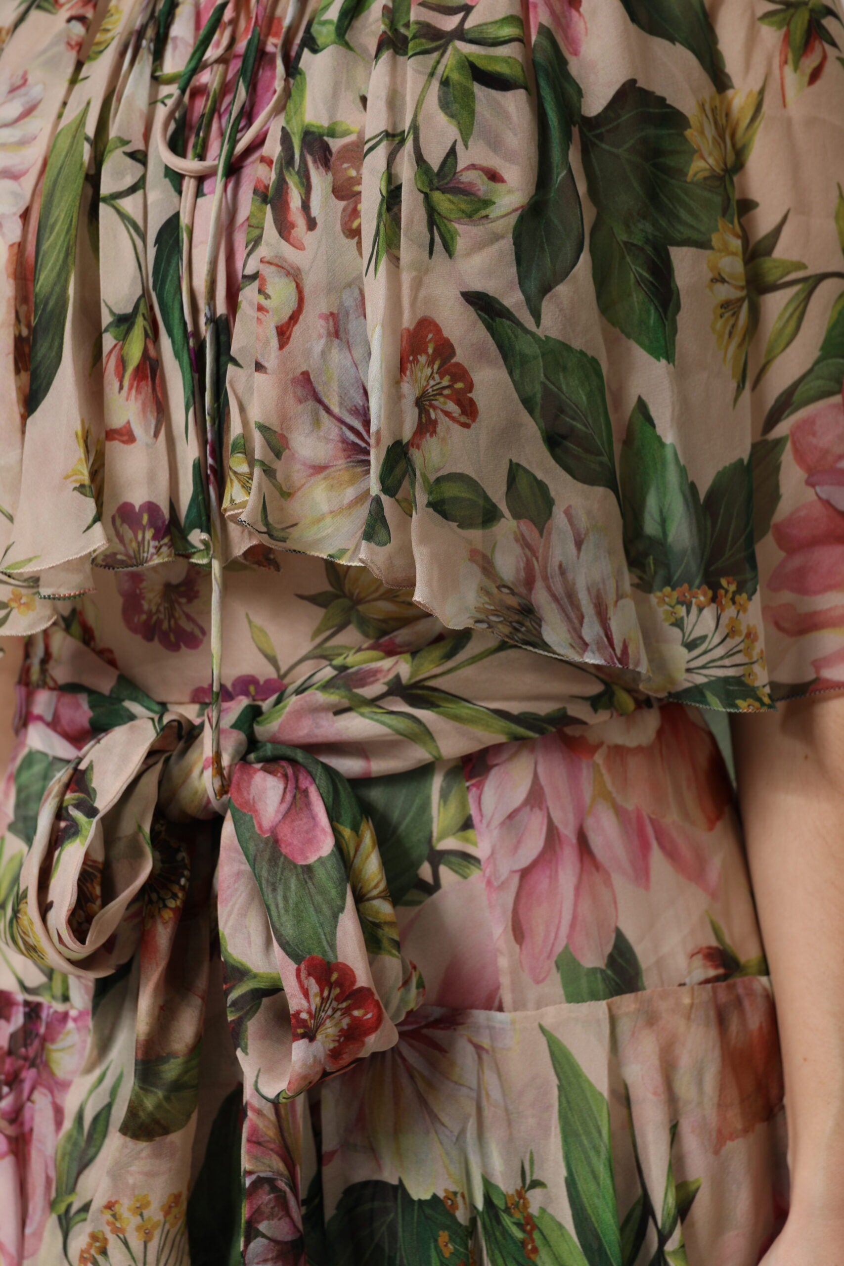 A woman wearing a long, tiered dress with pink floral print