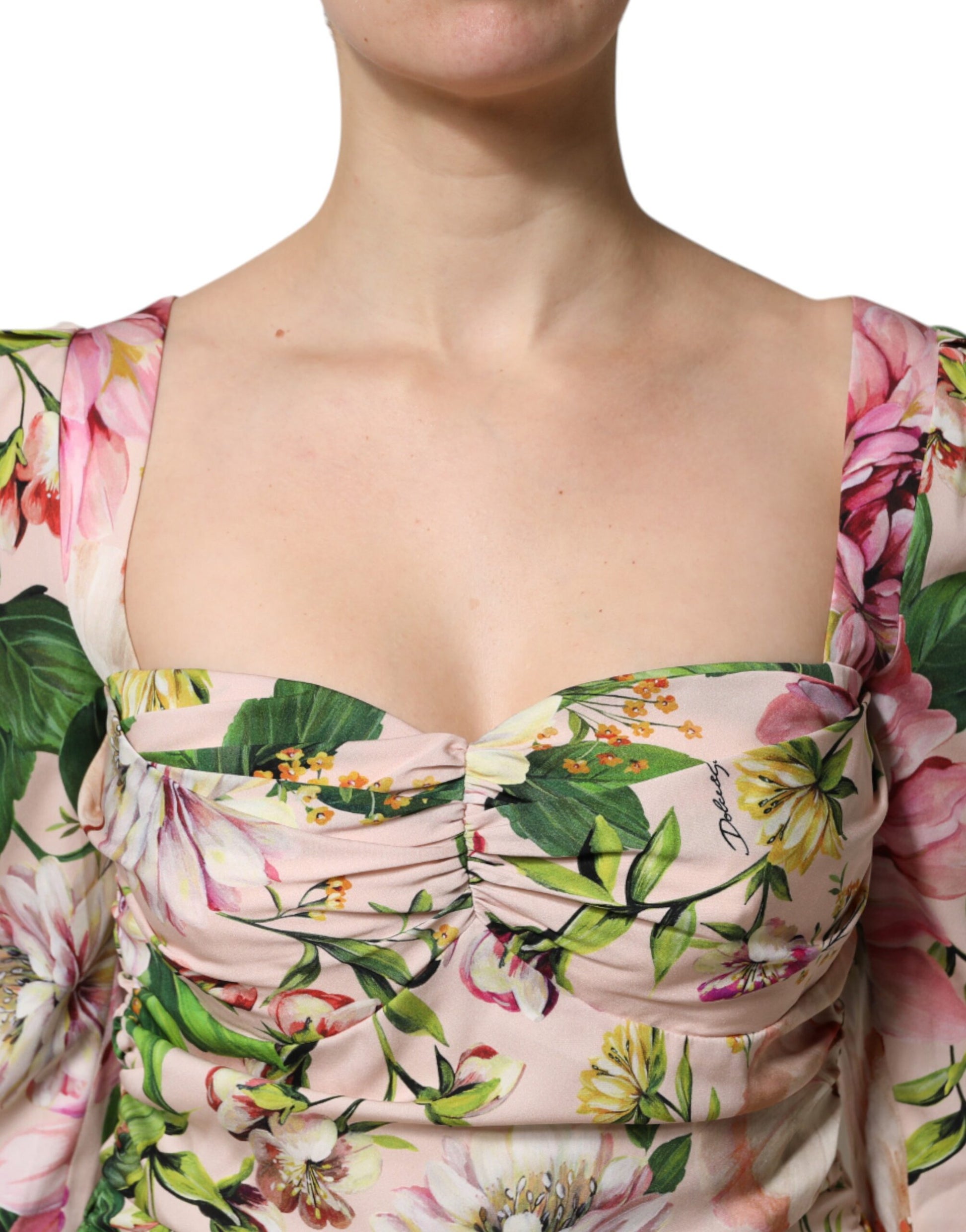 A pink floral silk midi dress with a fit and flare design