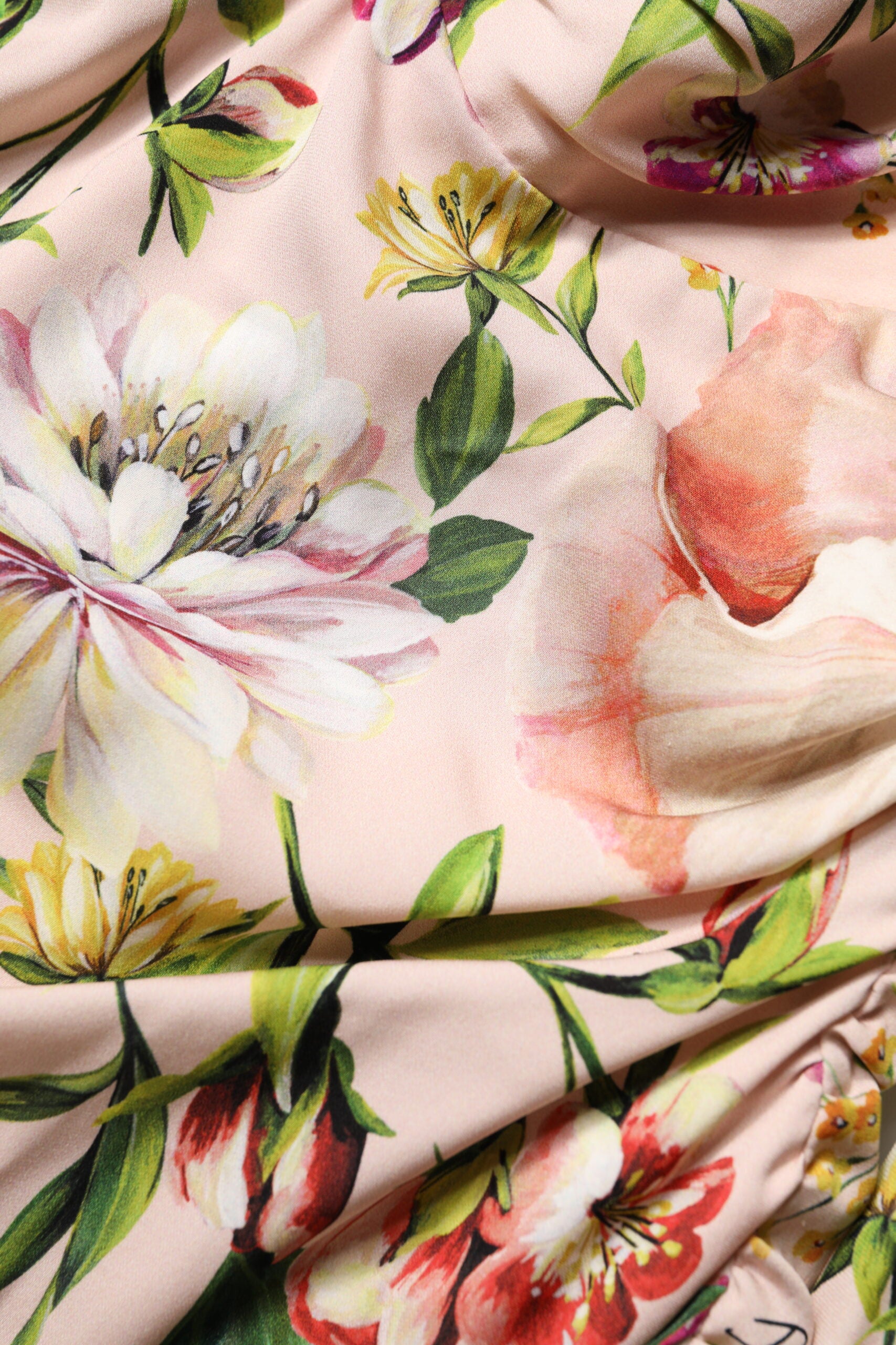 A pink floral silk midi dress with a fit and flare design