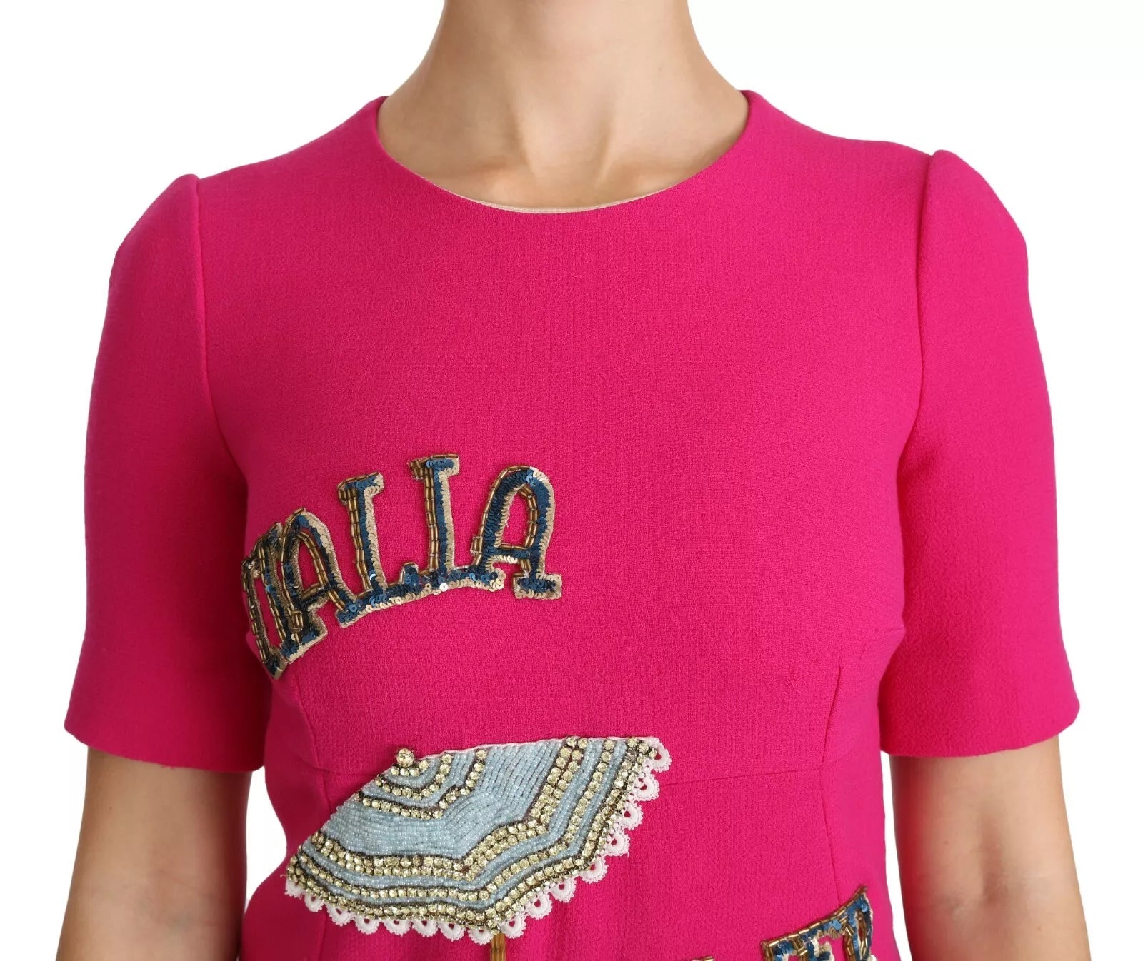 A pink dress with a crystal embellishment on the front, featuring the word "Italia" in blue