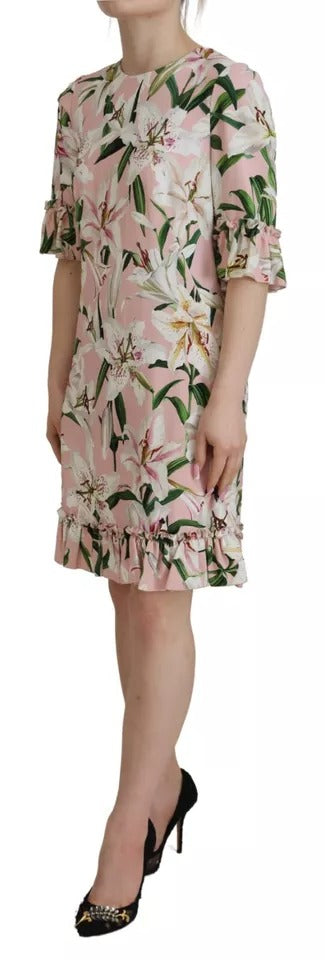 A woman wearing a pink floral dress with ruffled sleeves