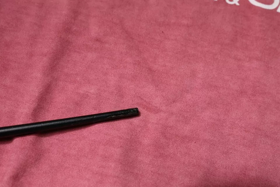 Black plastic piece on red fabric surface