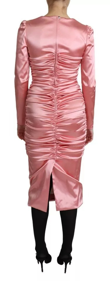A pink bodycon sheath midi dress with long sleeves and ruffled details