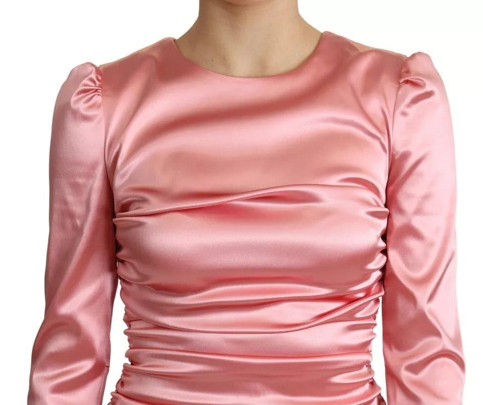 A pink satin bodycon sheath midi dress with long sleeves