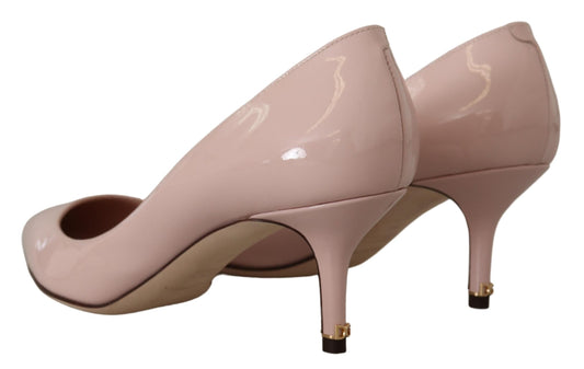 Pair of pink high heel shoes with pointed toe and gold accents