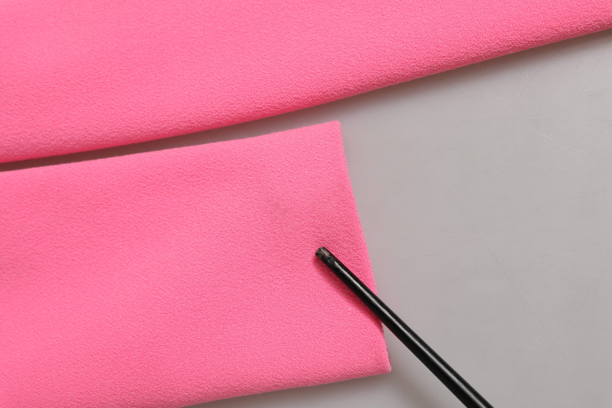 A pink polyester dress with long sleeves and a sheath style