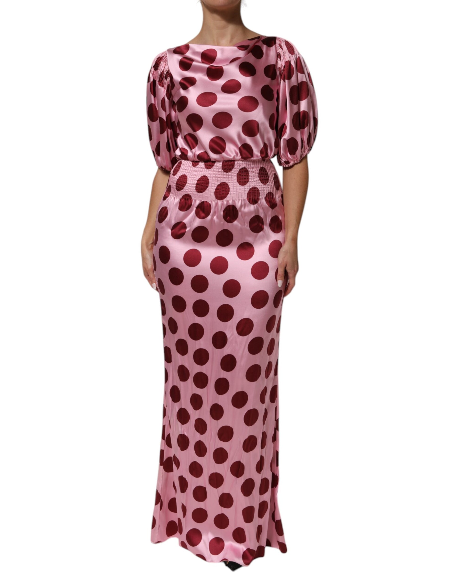A long pink dress with red polka dots and a silky satin finish