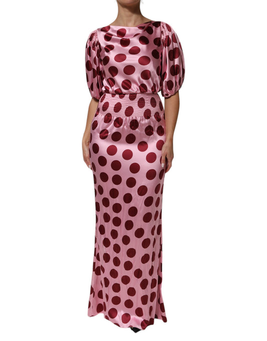 A long pink dress with red polka dots and a silky satin finish