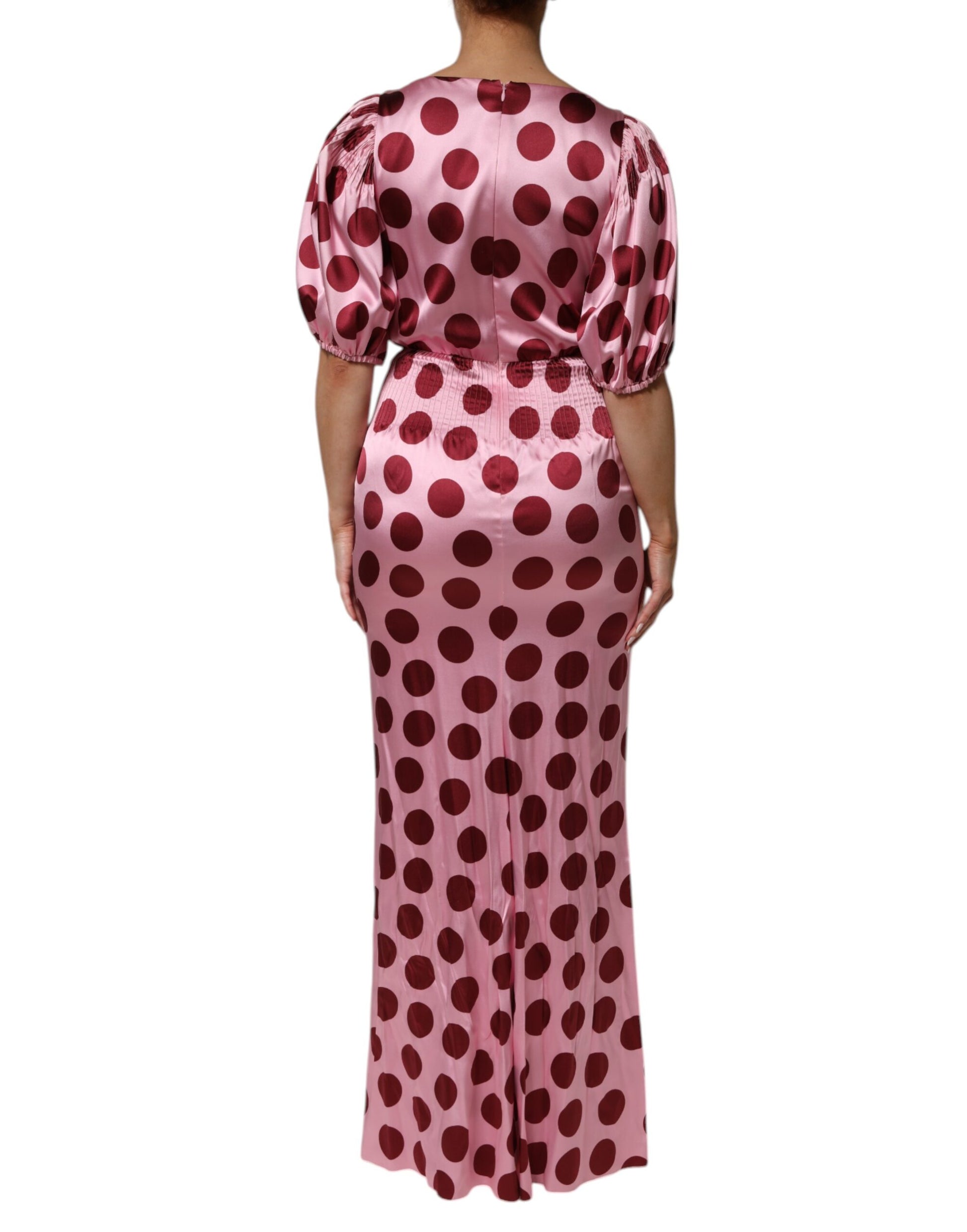 A long pink dress with red polka dots and a satin finish