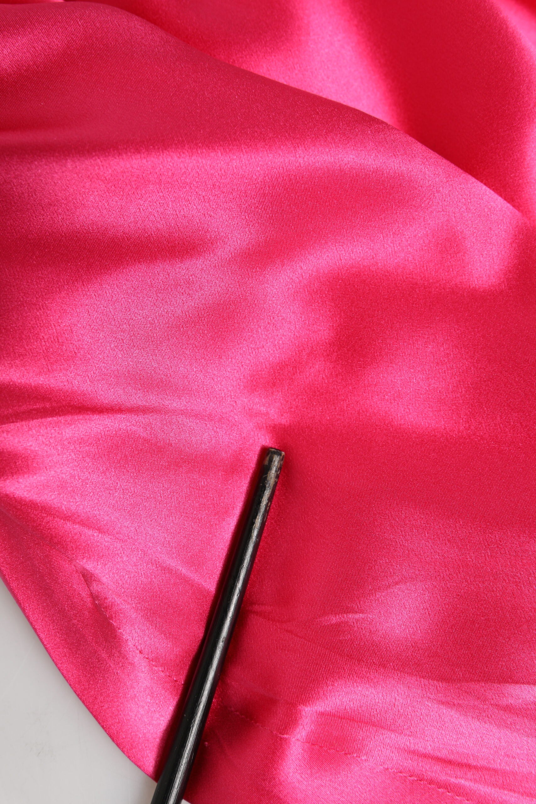 Black metal sewing needle on red fabric