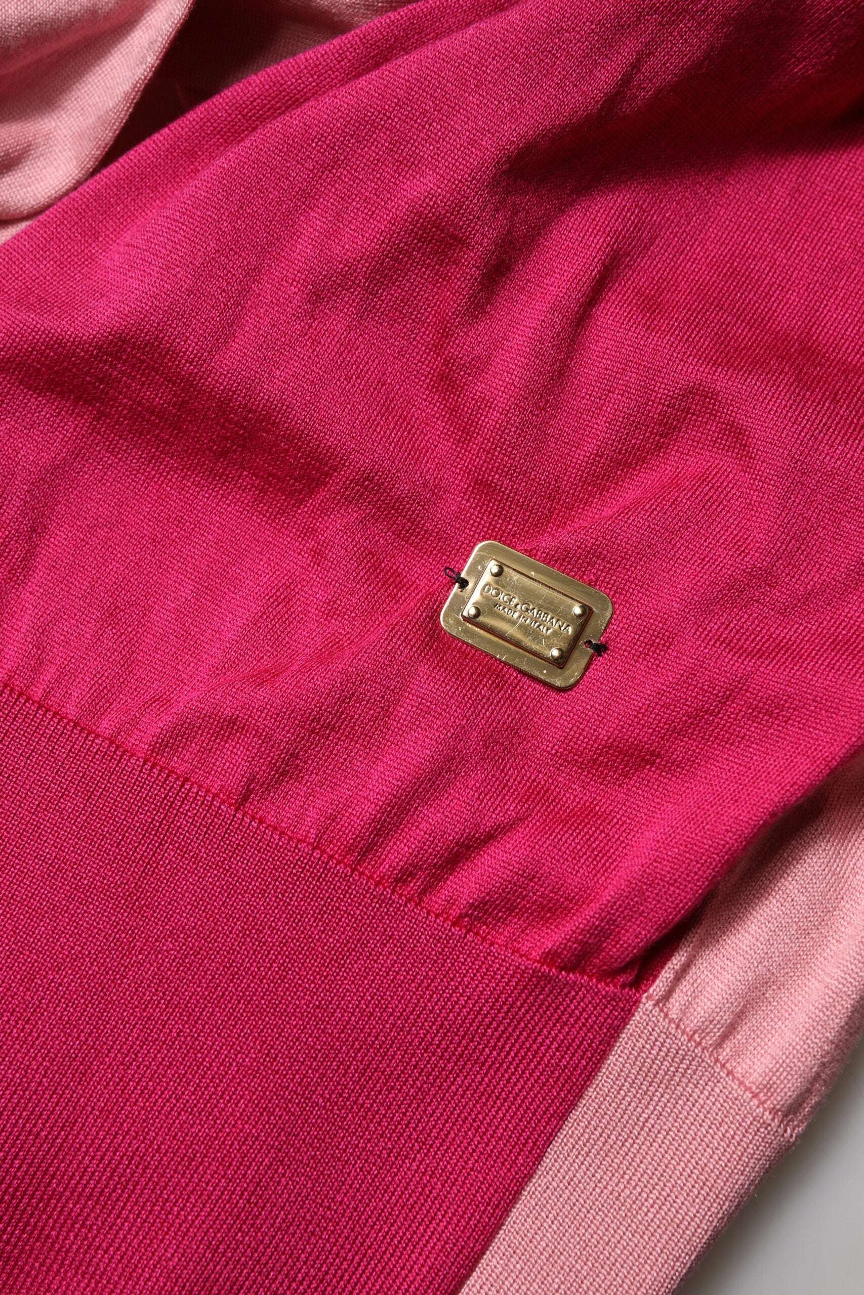Pink fabric with a small gold pin on it