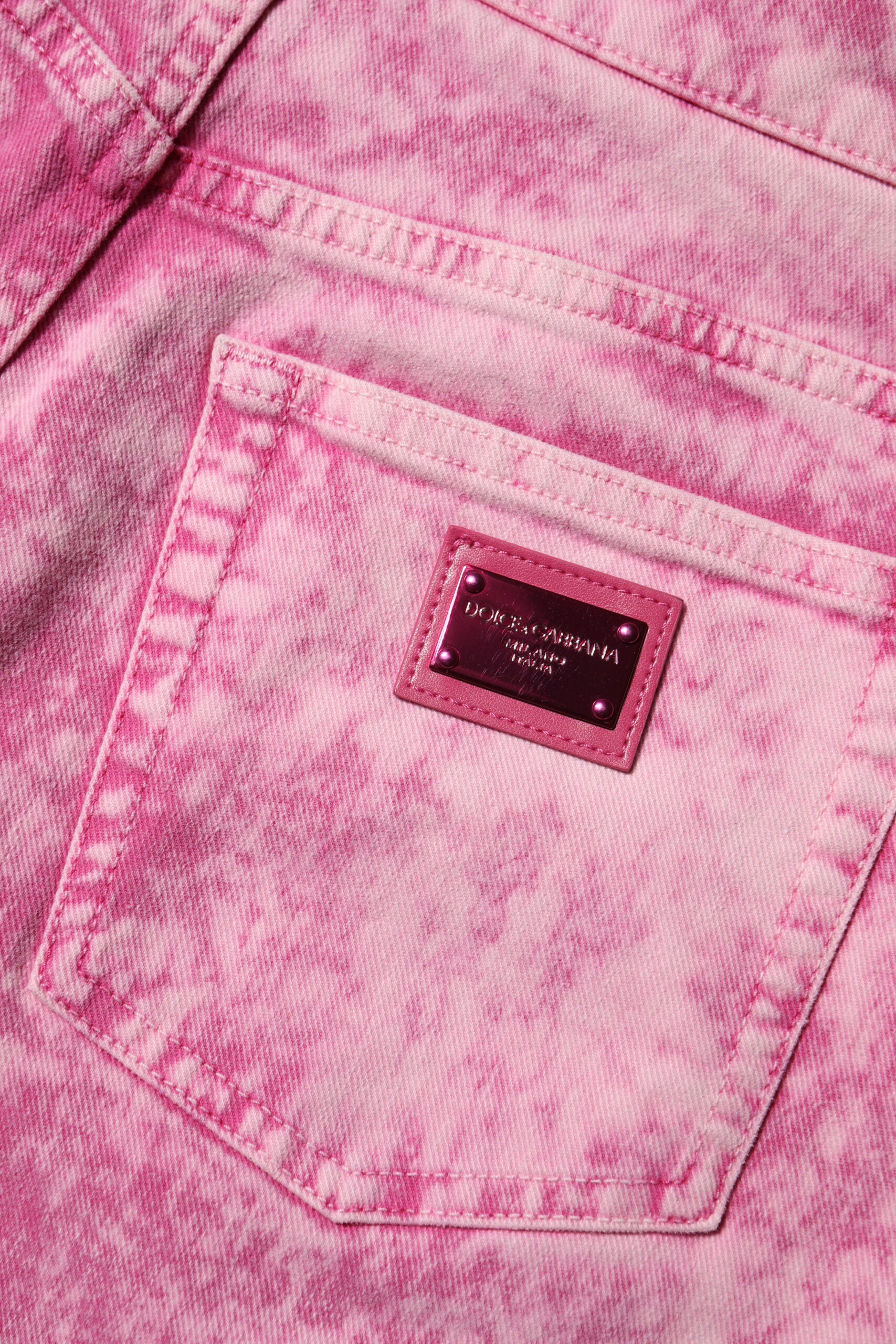 Pink jeans with a brand tag on the back pocket